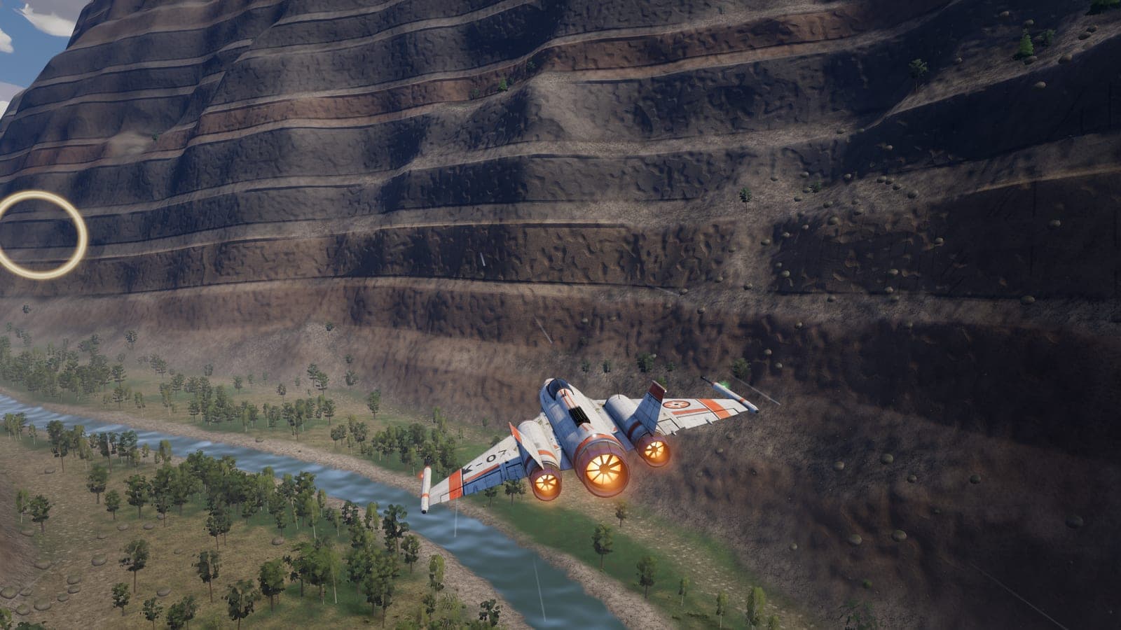 The interceptor flying low through a layered canyon above a river.